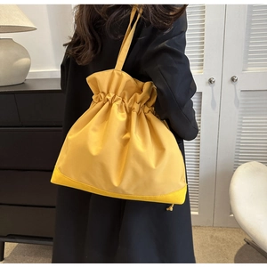 Fashionable yellow drawstring nylon tote bag with pleated top and long shoulder strap