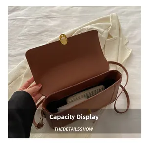 Vue détaillée de la capacité interne du sac en cuir marron avec un long portefeuille