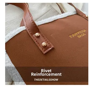 Detail of brown suede tote with white faux shearling trim and reinforced gold rivets