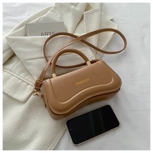 Close-up of caramel PU leather square handbag showing fashion text and smartphone scale