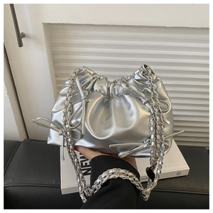 Detail of silver pleated bucket bag featuring metallic texture and bow ribbon accents
