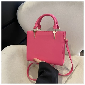 Macro detail of high-quality bright pink square handbag with stitching and leather handle
