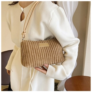 Close-up of brown corduroy shoulder bag showing soft ribbed texture and knotted strap details