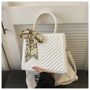 Détail du sac à main matelassé blanc avec foulard en soie sur l'anse et bandoulière