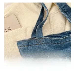 Detailed close-up showing reinforced contrast stitching on a durable blue denim tote bag