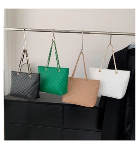 Row of quilted tote bags in black green camel and white with metal chain straps