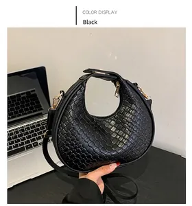 Dettaglio della borsa hobo intrecciata nera con hardware dorato e cerniera sulla scrivania