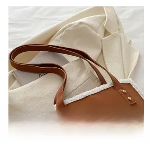 Close-up of brown faux leather tote with white shearling trim and NYISSA BAGS logo