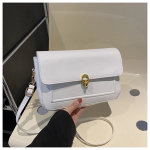 Détail du sac à rabat en cuir PU blanc avec fermoir rond doré et coutures fines