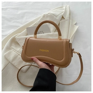 Detail of a brown PU leather crossbody bag with FASHION text and gold hardware