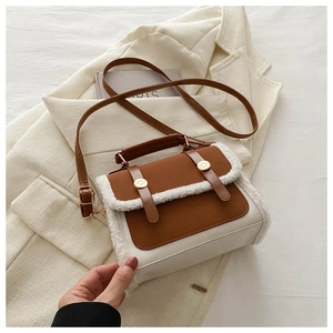 Close-up of retro color-block handbag with white fleece trim and gold buckle details