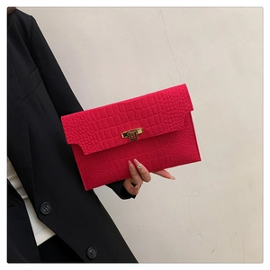 Detail of rose red crocodile pattern envelope clutch bag with gold metallic lock