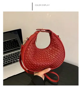 Dettaglio della borsa rossa in pelle PU intrecciata con fibbia dorata in ufficio