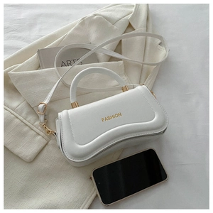 Detail of white PU leather handbag with gold 'FASHION' text and metallic hardware