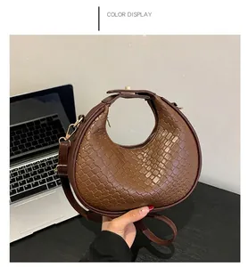 Dettaglio della borsa a mezzaluna intrecciata caffè con texture e fibbia in metallo oro
