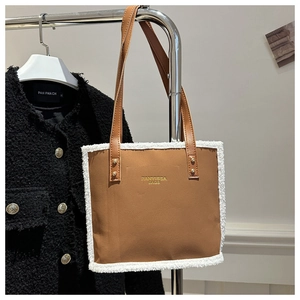 Brown square tote bag with white plush trim and golden hardware on a clothes hanger