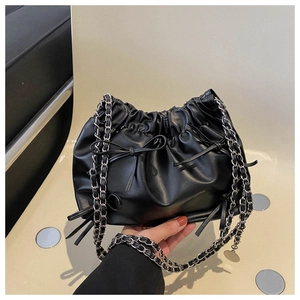 Detail of black pleated cloud bucket bag with bow decoration and leather chain strap
