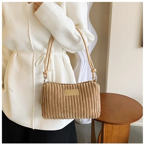 Detail of light brown corduroy shoulder bag showing fabric texture and knot handle