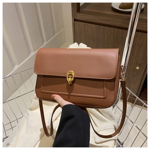 Détail du sac en cuir caramel avec boucle dorée et surpiqûres décoratives élégantes
