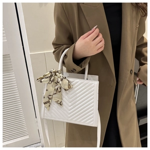 Elegant white quilted handbag with silk scarf handle wrap and detachable crossbody strap