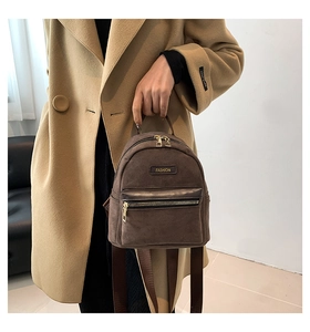 Detailed macro view of dark brown frosted texture mini backpack with golden zippers