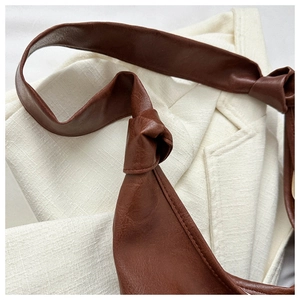 Detail of premium brown PU leather bag with minimalist knotted shoulder strap design