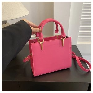 Detailed view of rose red rectangular handbag with gold hardware and stitch patterns