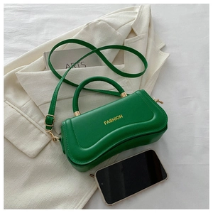 Detail of dark green wave-shaped PU leather handbag with golden fashion lettering