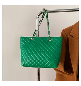 Dettaglio della borsa shopper verde trapuntata con catene dorate e occhielli in metallo