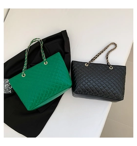 Dettaglio di borse tote trapuntate in verde e nero con tracolla a catena dorata lucida