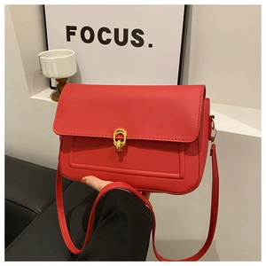 Détail du sac rouge semi-circulaire montrant le fermoir doré et les coutures de qualité