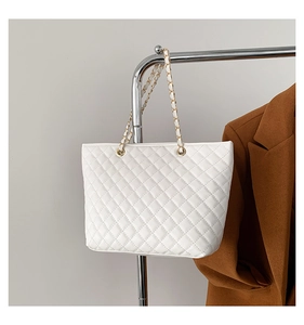 Dettaglio della borsa tote trapuntata bianca con catena in metallo dorato e tracolla in pelle