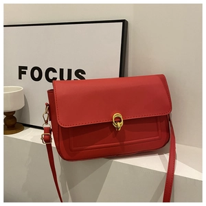 Détail du sac rouge à bandoulière avec boucle dorée et coutures élégantes