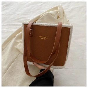 Close-up of brown suede tote bag with white faux fur trim and FANYISSA brand lettering