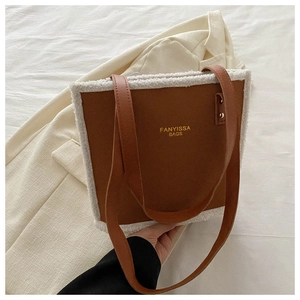 Brown faux suede tote bag featuring white shearling trim and gold rivet handle details