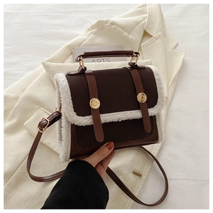 Detail showing vintage brown crossbody bag with white faux fur trim and golden buckle