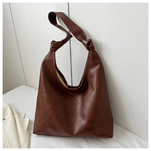 Detailed close-up of brown PU leather hobo bag with unique shoulder strap knot design