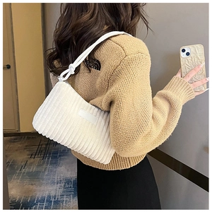 Detail of white corduroy shoulder bag with vertical striped texture on a model