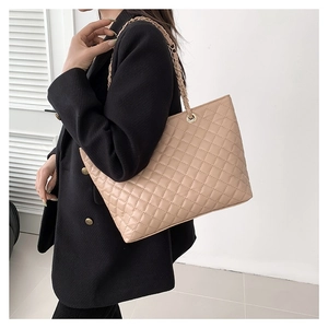 Elegante borsa shopper trapuntata color albicocca indossata da una modella in stile minimal