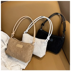 Flat lay of corduroy shoulder bags in khaki, off-white, and black with knot detail