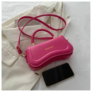 Detail of fuchsia PU leather handbag showing gold fashion lettering and curved base design
