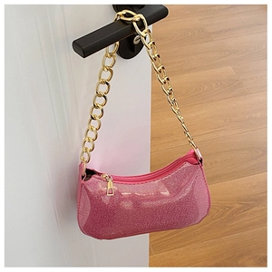 Detail of pink sequin texture and thick gold chain strap on stylish shoulder bag