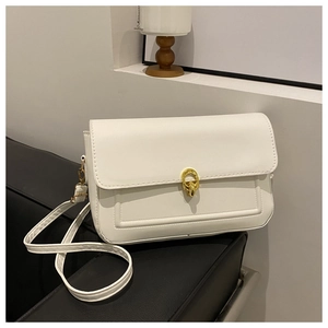 Vue détaillée du sac bandoulière en similicuir blanc avec boucle dorée sur siège en cuir noir