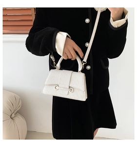 Detail of white woven texture handbag with metal hook and elegant top handle