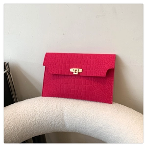 Detail of rose red envelope clutch featuring crocodile pattern and golden metal buckle
