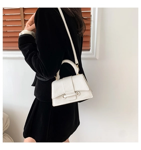 Detail of white crossbody bag with elegant vertical wave weave texture and thin shoulder strap