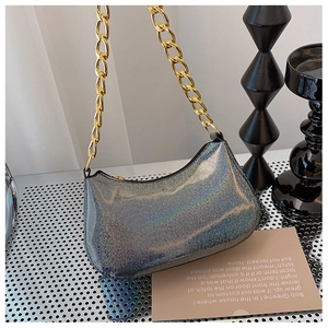 Close-up of holographic sequin baguette bag with thick gold metal chain strap details