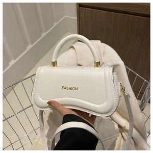Detail of white semi-moon structured handbag with gold fashion lettering and metal hardware