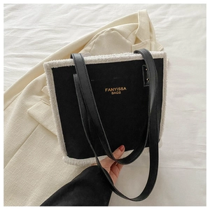 Chic black tote bag with white faux fur trim and gold lettering on shoulder straps