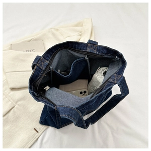 Top view of spacious interior in navy denim tote bag showing pockets and daily items
